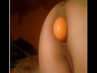 Teen plugging an orange ball in her ass