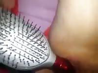 Horny lady using a comb as a dildo